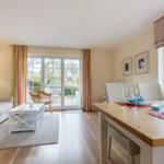 Living and dining area with table, sofa, and terrace door.
