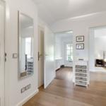 Hallway with kitchen area, mirror, and view into bedroom and living area.