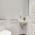 Bathroom with toilet, sink, and heater