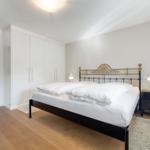 Bedroom with bed, wardrobe, and bedside table.
