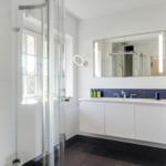 Bathroom with shower, sink, and mirror.