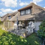 House with thatched roof, terrace and garden. Furnished outdoor terrace with table and chairs.