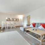 Living and dining area with sofa, table, and chairs.