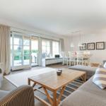 Living and dining area with sofa, coffee table, and TV. Access to terrace and garden.