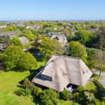 Thatched house with garden. View of the lake in the background.