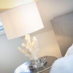 Bedroom with nightstand, lamp, and coral decor.