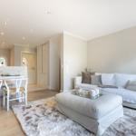 Living and dining area with white sofa, coffee table, and dining table with chairs.