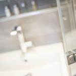 Bad mit Waschbecken und Dusche mit Glaswand