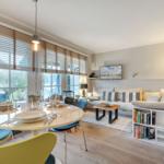Essbereich mit runder Tafel und Sitzgelegenheiten. Wohnbereich mit Sofa, Couchtisch und Bücherregal.