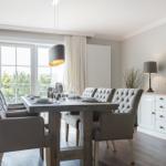 Esszimmer mit Tisch, Stühlen und Blick auf Garten.