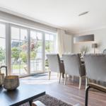 Großes Esszimmer mit Tisch, Stühlen und Blick auf Garten