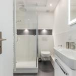 Dusche, Toilette und Waschbecken in moderner Badezimmerausstattung.