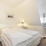 Bedroom with double bed, two nightstands, and window with awnings.