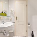 Bathroom with sink, mirror, toilet, and shower