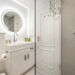 Badezimmer mit Dusche, Waschbecken und Spiegel