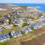 Luftbild von Häusern am Meer mit Strand und Grünflächen