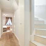 Hallway with stairs and view into bedroom with bed and window
