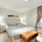 Bedroom with bed, nightstands, and window with curtains.