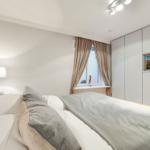 Bedroom with bed, nightstand, window, and wardrobe.