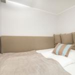 A bed with brown cushions and a striped cushion pillow.