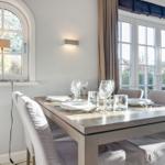 Dining room with table, chairs, and windows.