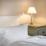 Bed headboard with pillow and bedside table with lamp