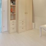 Bedroom with wardrobe, desk, and lamp.