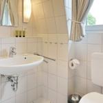Bathroom with sink, toilet, and window.