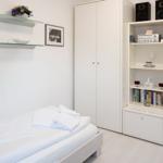 Bedroom with bed, wardrobe, and bookshelf.