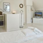 Bedroom with bed, TV, and wardrobe.
