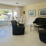 Living and dining area with black leather furniture and large window to terrace.