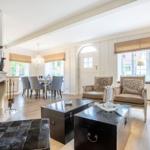 Living and dining area with fireplace, seating, and windows.