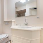 Bathroom with sink, mirror, and toilet.