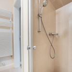 Shower cabin with handheld shower and wall-mounted heater
