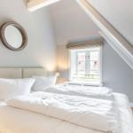 Bedroom with sloped ceiling, bed, and window.