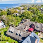 Village with thatched roofs, green areas, and sea view.