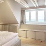 Schlafzimmer mit Blick aufs Meer und Dachschräge