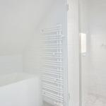 Badezimmer mit Badewanne und Dusche mit Glaswand.
