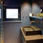 Badezimmer mit blauen Wänden, Waschbecken und Duschbereich.