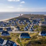 Village with beach and lighthouse by the coast