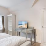 Schlafzimmer mit Doppelbett, Schreibtisch und Fenster mit Blick.