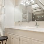 Badezimmer mit Doppelwaschbecken, Spiegel und Heizung