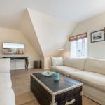 Wohnzimmer mit Sofa, Couchtisch und Fernseher unter Dachschrägen