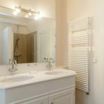 Bathroom with double sink, mirror, and radiator