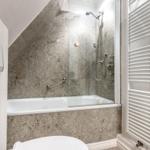 Badezimmer mit Dusche, Badewanne und Heizkörper