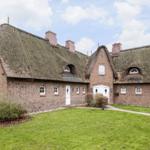 Dorfhaus mit strohgedecktem Dach und gemauertem Außenbereich.