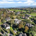 Village with thatched roofs, green meadows, and view of the North Sea.