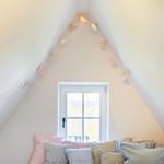 Schlafzimmer mit Dachschrägen, Fenster und Kissen
