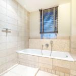 Bad mit Dusche und Badewanne, Fenster mit Jalousie, Fliesenwand