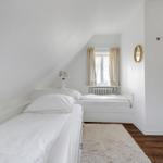 Room with two beds, window, and mirror on the wall.